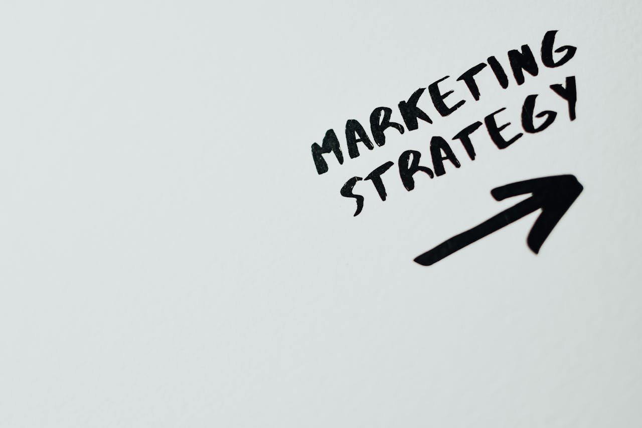 services-hero Close-up of handwritten Marketing Strategy text with an arrow on white background.