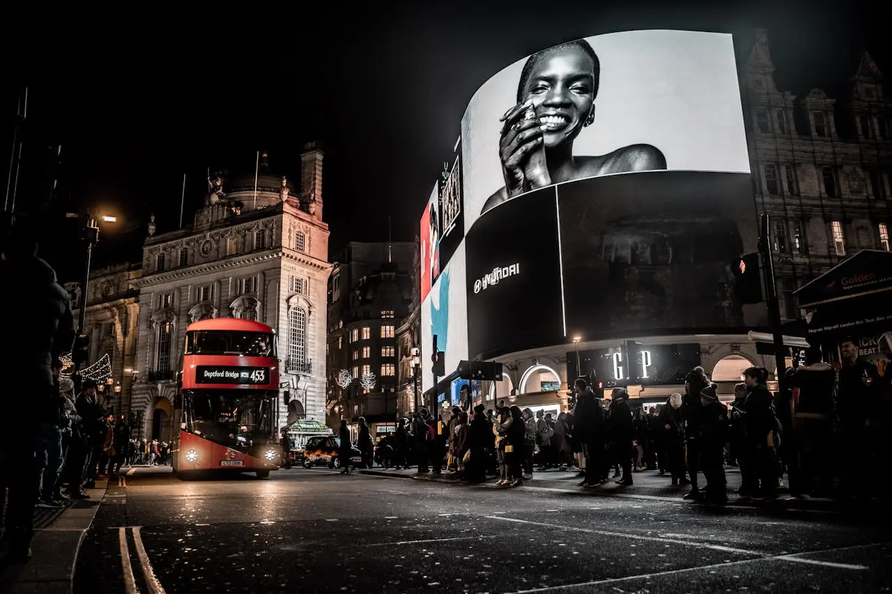 services-01 Vibrant city life at night in Piccadilly Circus, London with double-decker bus and illuminated billboards.