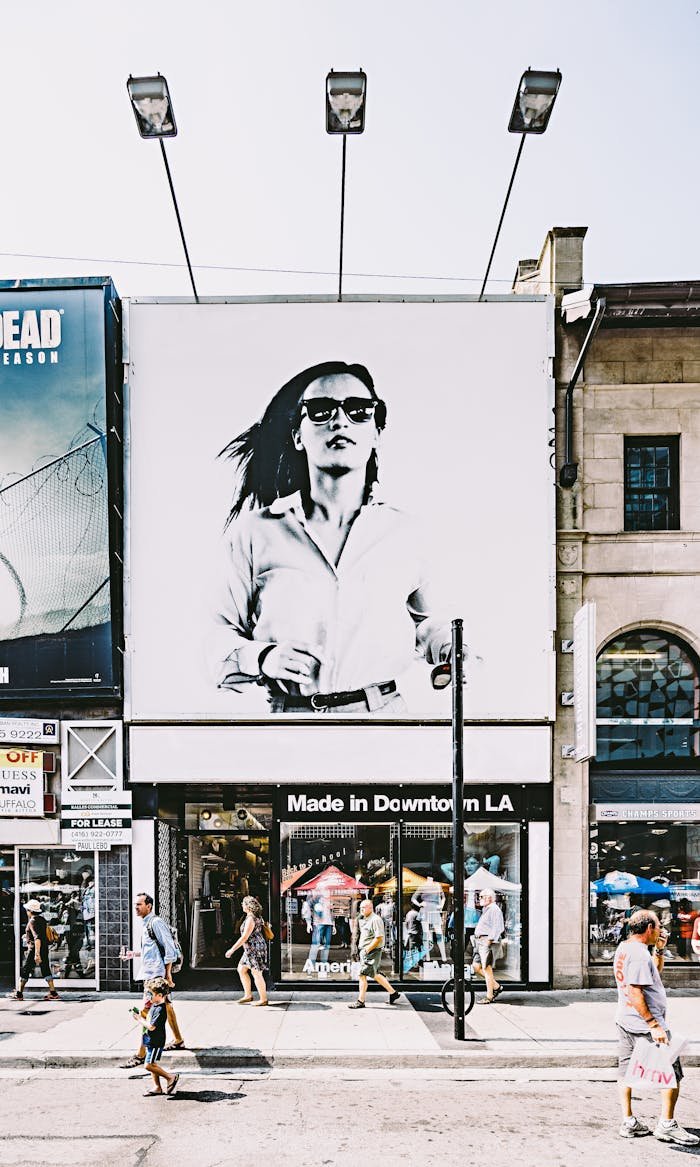 home-hero Busy Toronto street with shops, people, and large advertisement in urban setting.