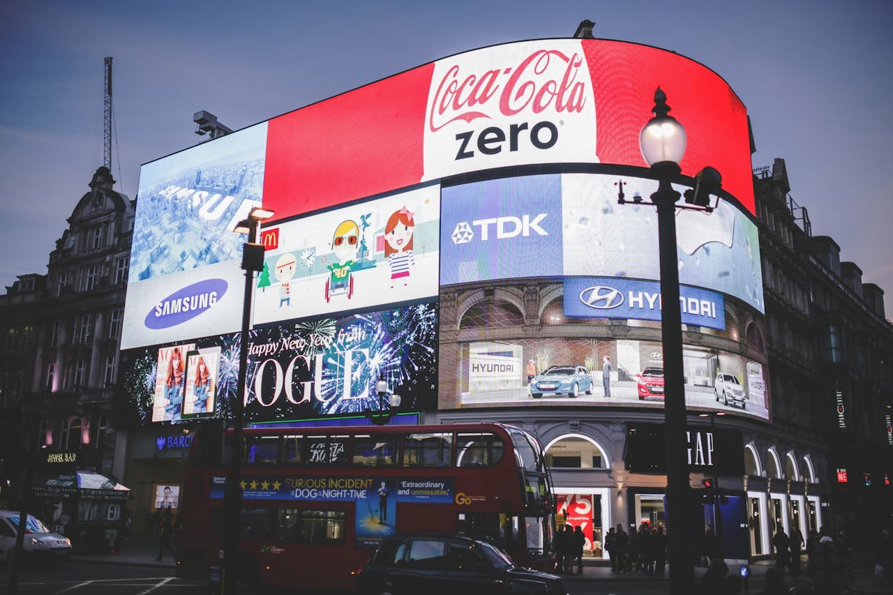 services-05 Night view of Piccadilly Circus in London with bright billboards and a red double-decker bus.